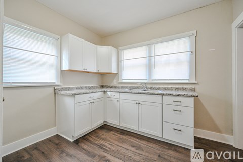 A kitchen with white cabinets and a granite countertop.