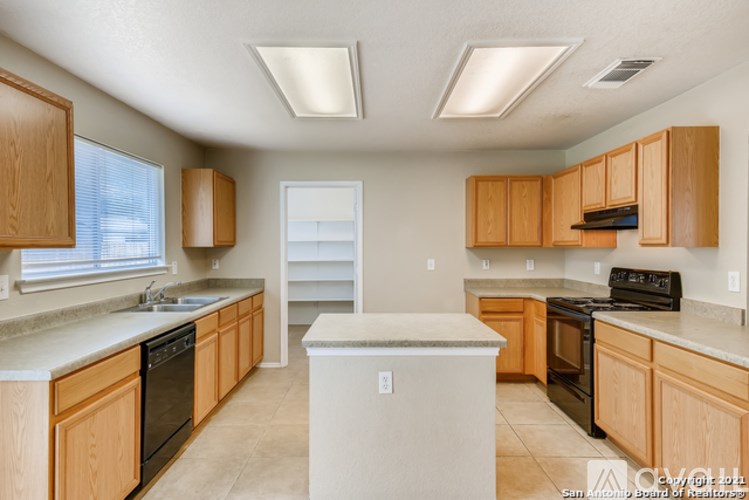 A kitchen with wooden cabinets and a white island.