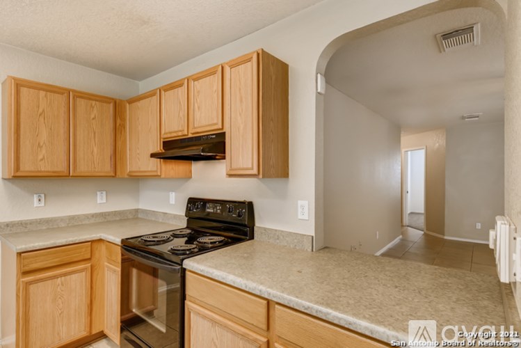 A kitchen with wooden cabinets and a black stove top oven.