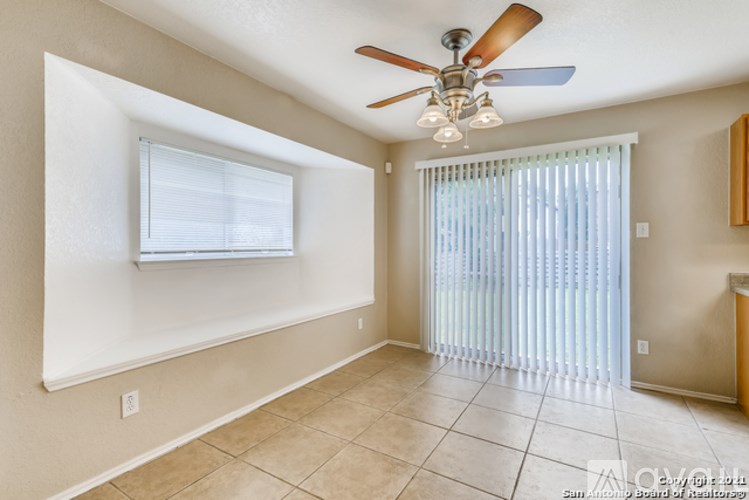 A room with a ceiling fan and a window with blinds.