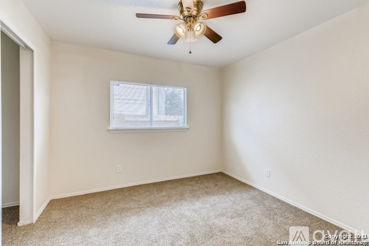 A room with a ceiling fan and a window.