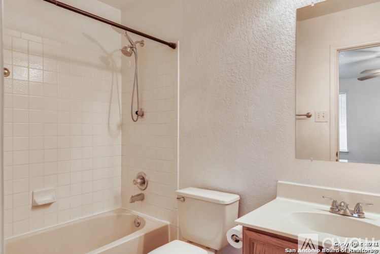 A white bathroom with a tub, toilet, and sink.