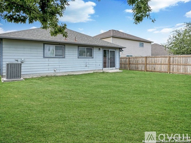 A house with a fence and a green lawn.