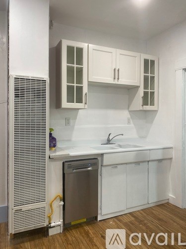 A kitchen with white cabinets and a stainless steel dishwasher.