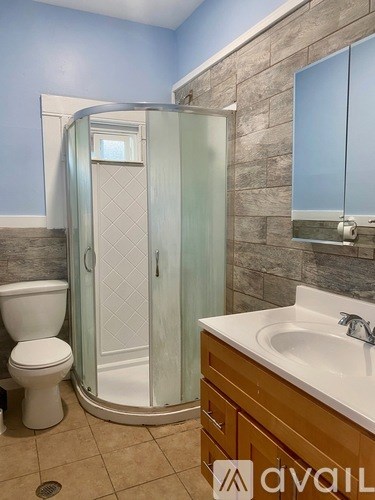 A bathroom with a toilet, sink, and shower stall.