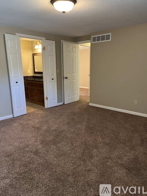 A carpeted room with a brown carpet and a white door.