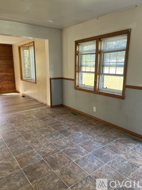 A room with a tiled floor and a window with blinds.