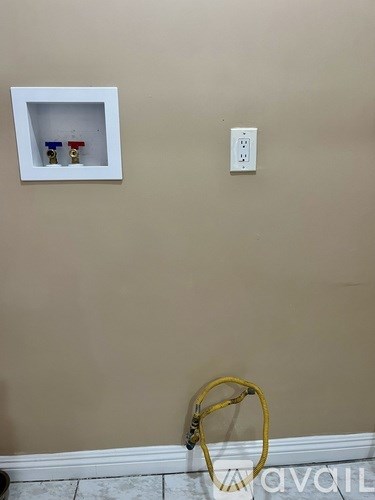 A white electrical outlet on a beige wall.