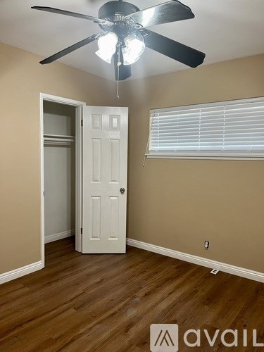 A room with a white door and a ceiling fan.