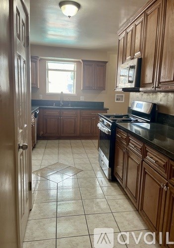 A kitchen with wooden cabinets and a black stove top oven.
