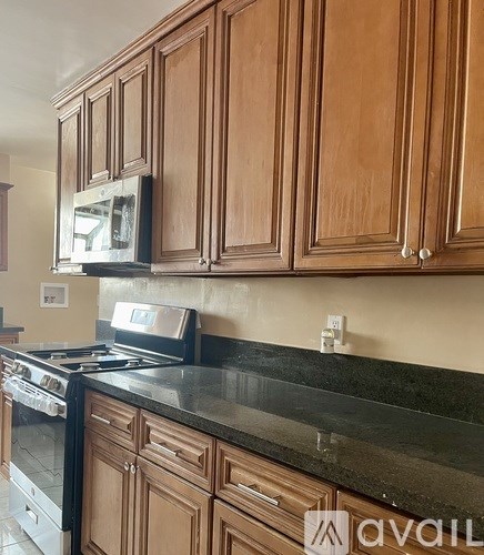 A kitchen with wooden cabinets and a black countertop.