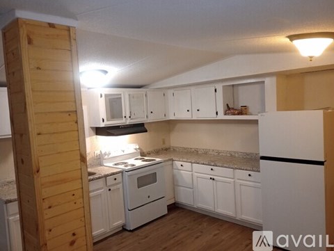 A kitchen with white cabinets and a wooden door.
