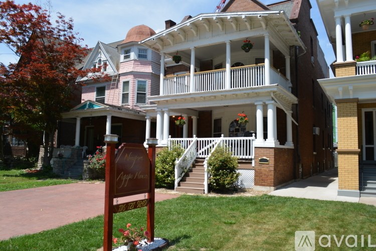 A sign in front of a house that says "For Sale".