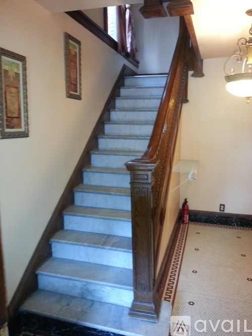 A staircase with a wooden banister and a marble stair tread.