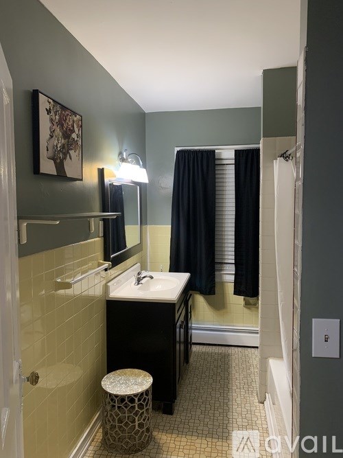 A bathroom with a sink, mirror, and a stool.