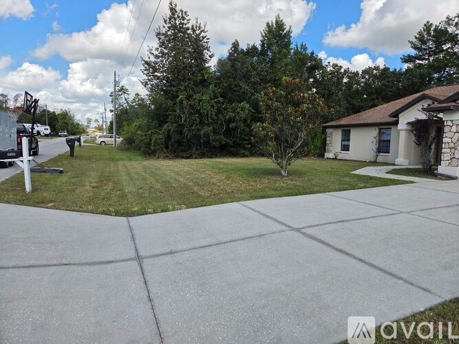 A house with a driveway and a tree in front of it.