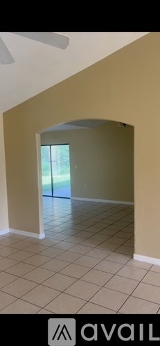 A room with beige walls and a white ceiling with a fan.