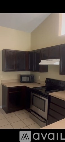 A kitchen with brown cabinets and a black stove top oven.