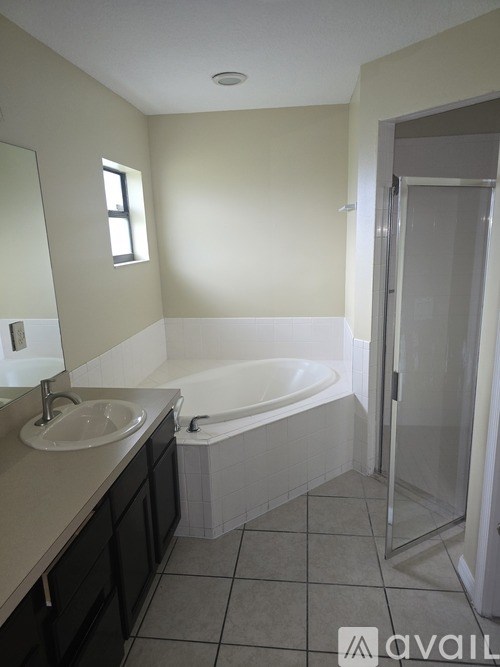 A bathroom with a sink, mirror, and bathtub.
