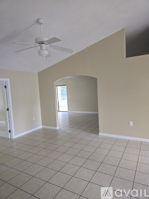A room with a ceiling fan and tiled flooring.