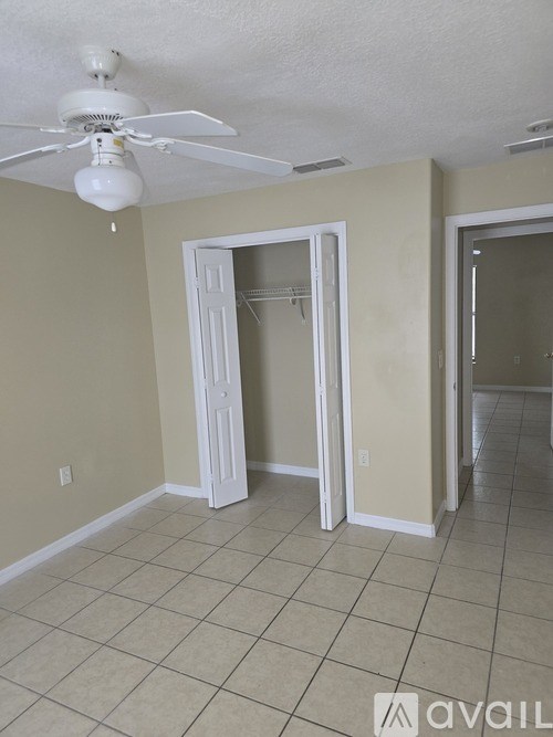 A room with a ceiling fan and tile flooring.