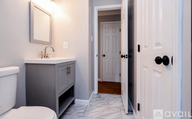 A bathroom with a toilet, sink, and mirror.