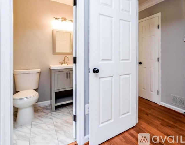 A bathroom with a toilet, sink, and mirror.