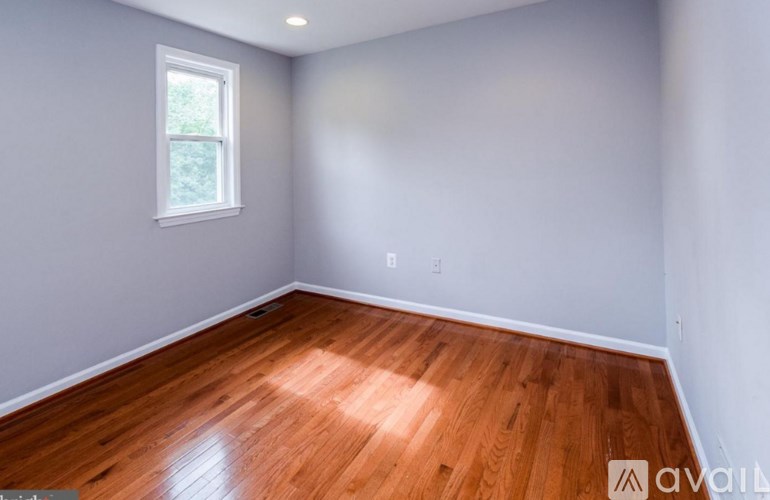 A room with wooden flooring and a window.
