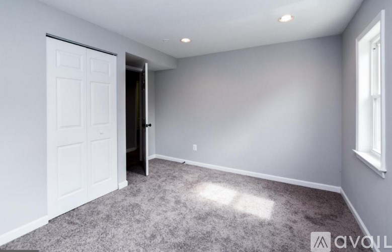 A room with a white door and carpeted floor.