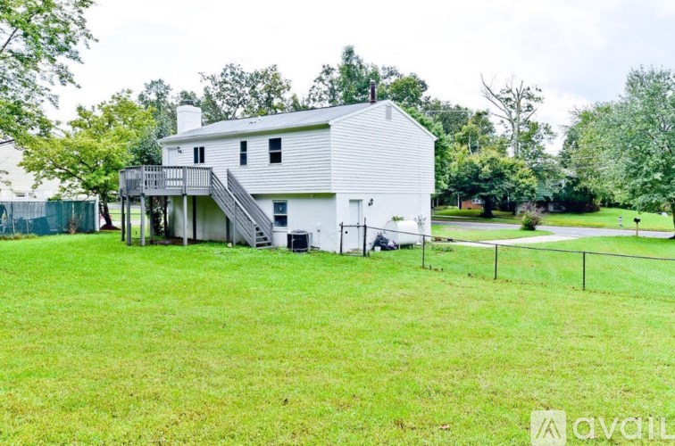 A white house with a green lawn in front.