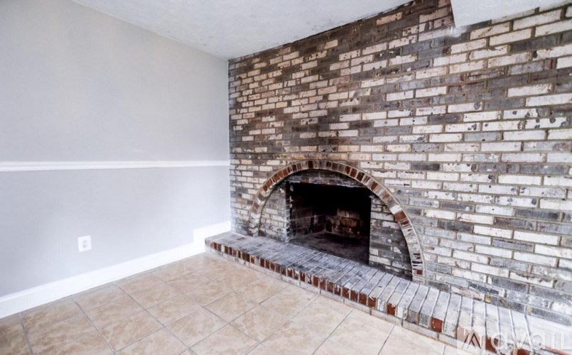 A brick fireplace in a room with a tiled floor.