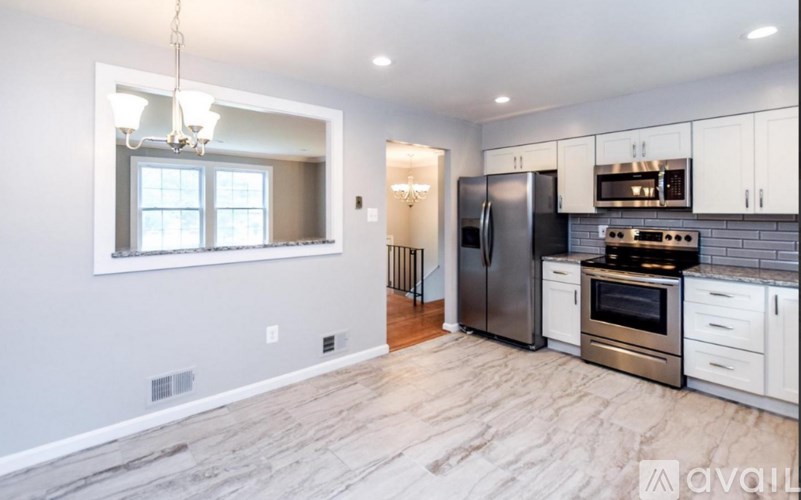 A kitchen with a refrigerator, oven, and microwave.