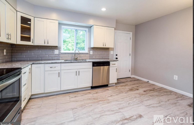 A kitchen with a sink, stove, and cabinets.