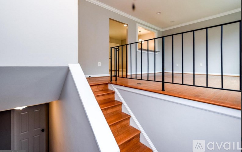 A staircase with a black railing and wooden steps.