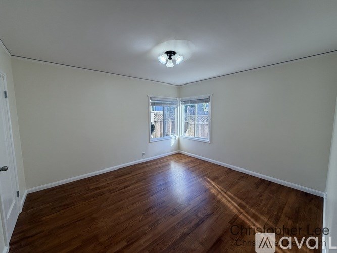 A room with wooden floors and a window overlooking a cityscape.