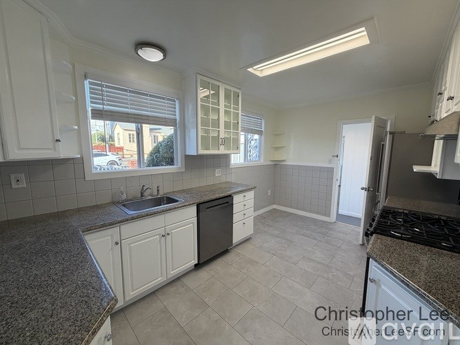 A kitchen with granite countertops and white cabinets.