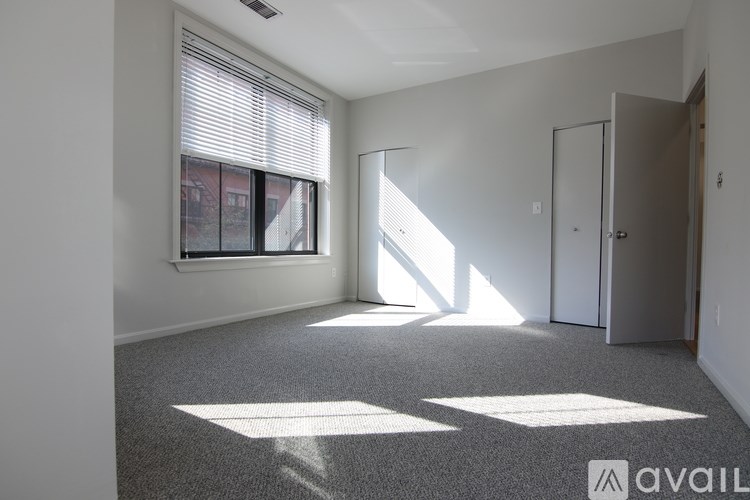 A room with a window and a door is available for rent.