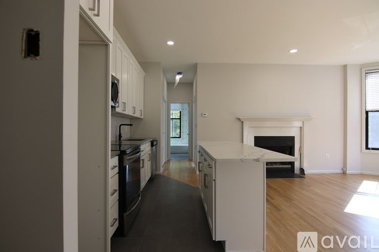 A modern kitchen with white cabinets and a black countertop.