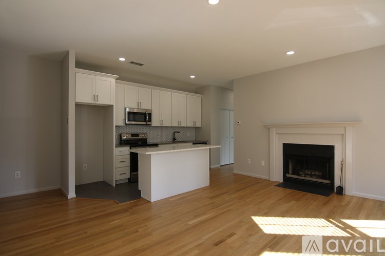 A modern kitchen with a fireplace in the living room.