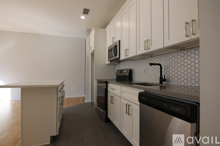 A kitchen with black countertops and white cabinets.