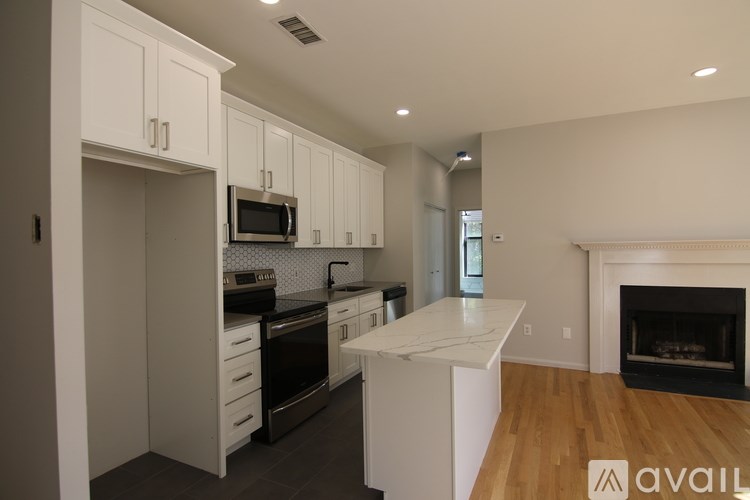 A modern kitchen with white cabinets and a black stove top oven.
