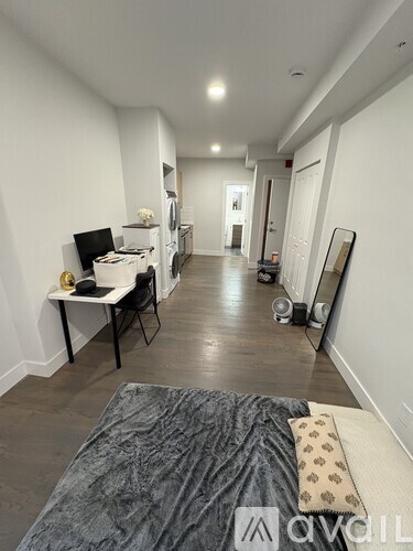 A room with a bed, desk, and chair.