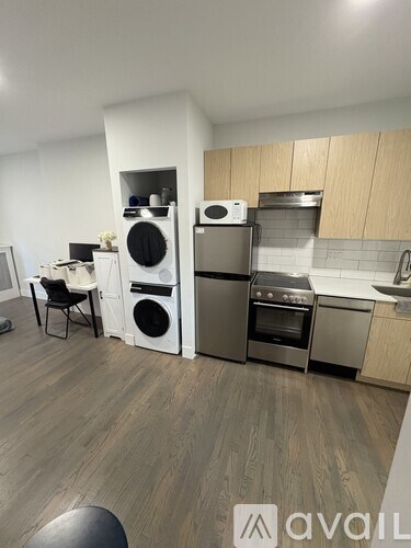 A modern kitchen with a washing machine and dryer built into the cabinetry.