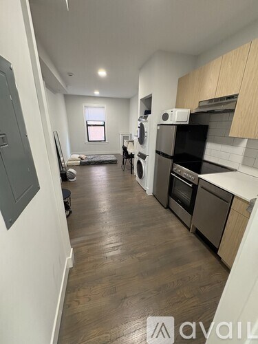 A kitchen with wooden floors and a washing machine in the corner.