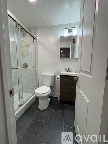 A white toilet in a bathroom with a glass shower door.