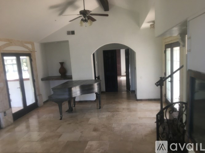 A room with a grand piano and a fan.