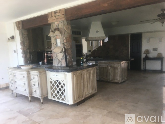 A kitchen with a stone pillar and wooden cabinets.