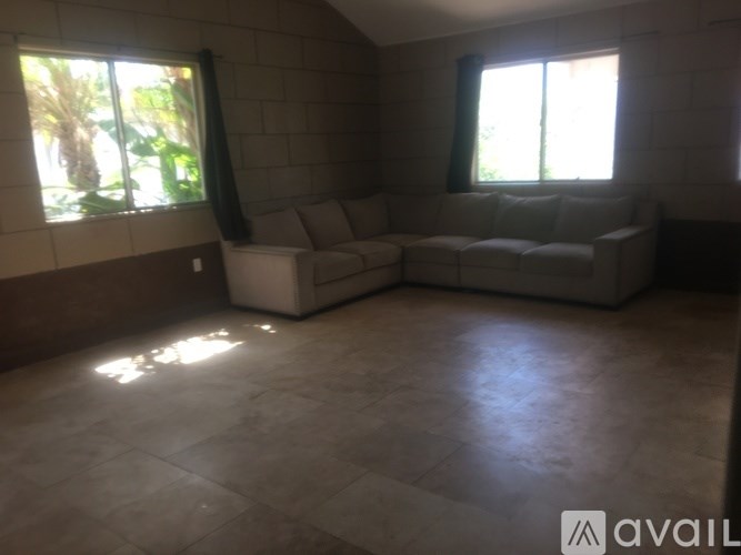 A living room with a couch and a window.