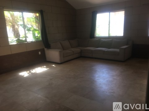 A living room with a couch and a window.
