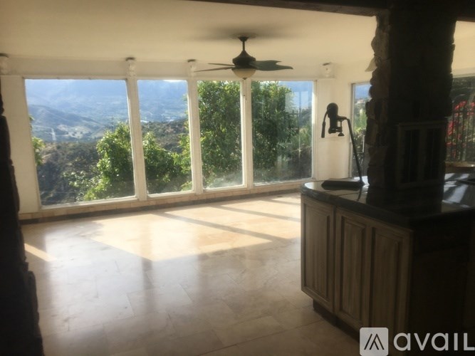 A room with a fan and a view of the mountains.